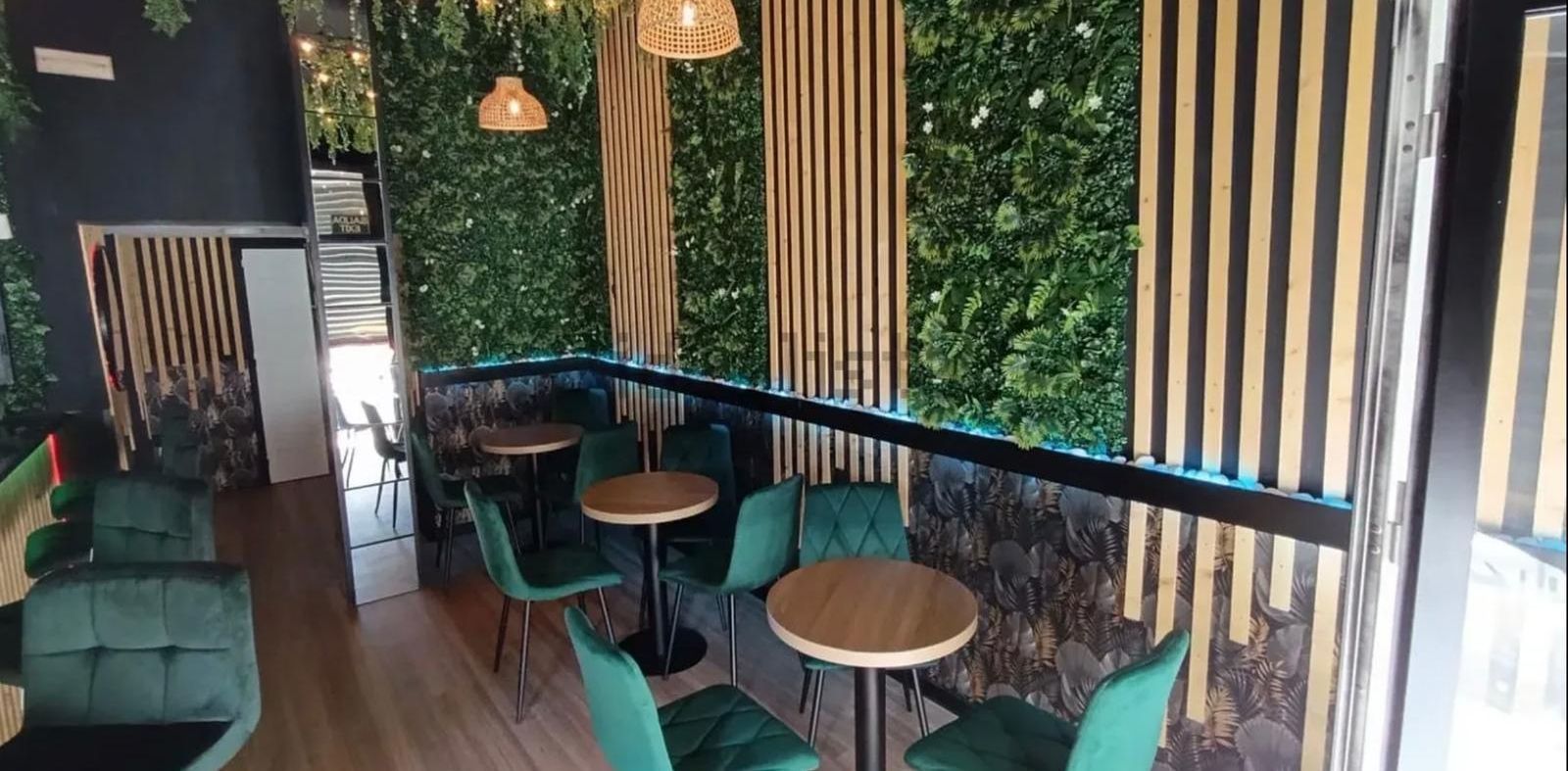 Bar-cafetería: Mesas junto al jardín vertical
